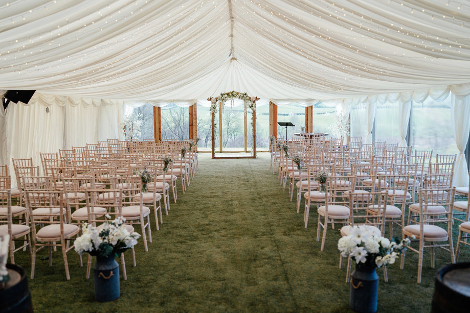 Ceremony room with chairs decorated with draped ceiling and fairy lights